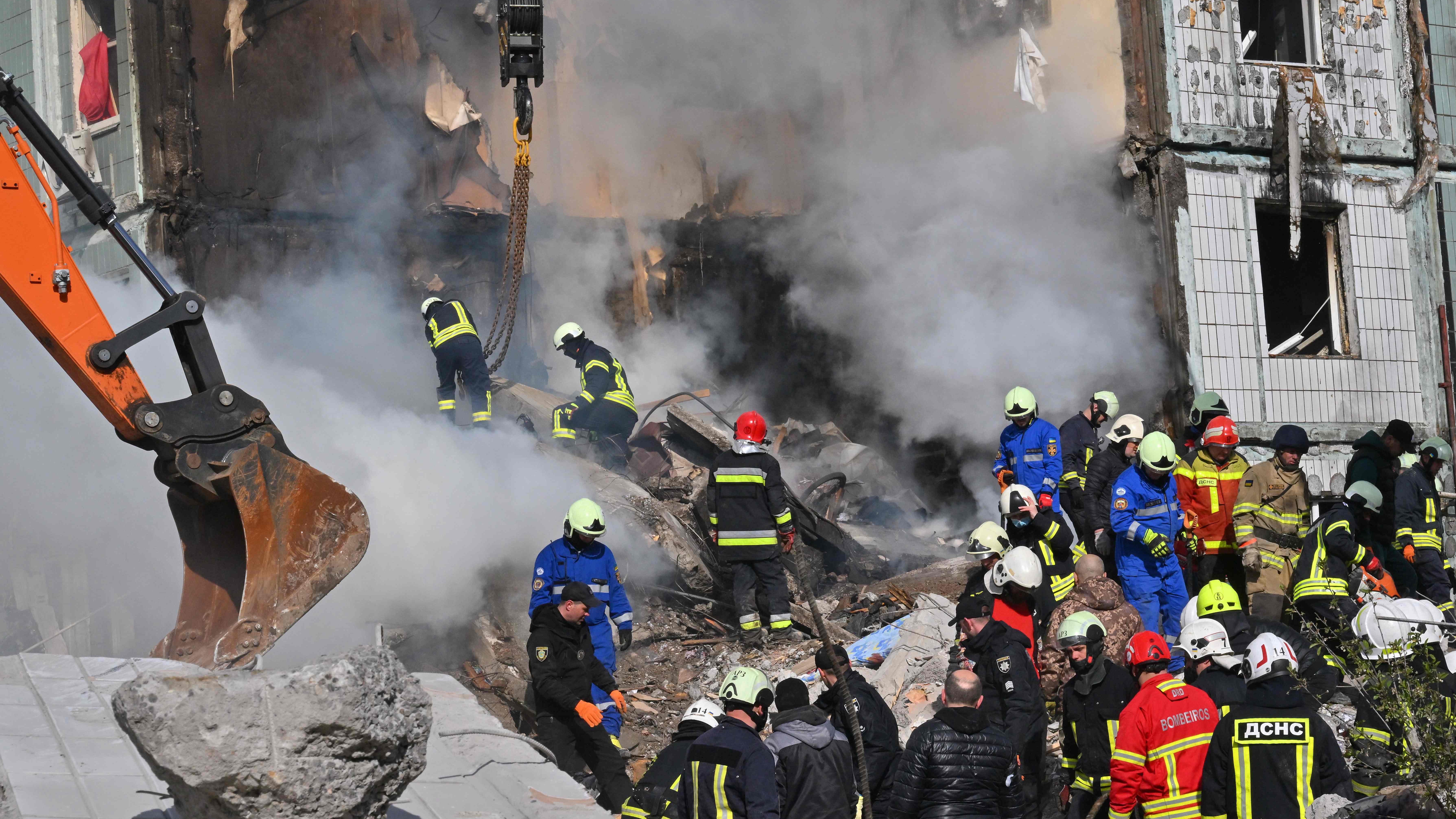 Rescuers search for survivors in the rubble next to a damaged residential building in Uman, southern Kyiv on April 28, 2023, after Russian missile strikes targeted several Ukrainian cities overnight.