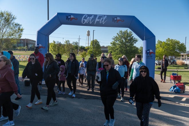 Walkers pass the start line at the Bridge Children's Advocacy Center "Walk A Mile in Their shoes" walk/run Saturday morning at its location in Amarillo.