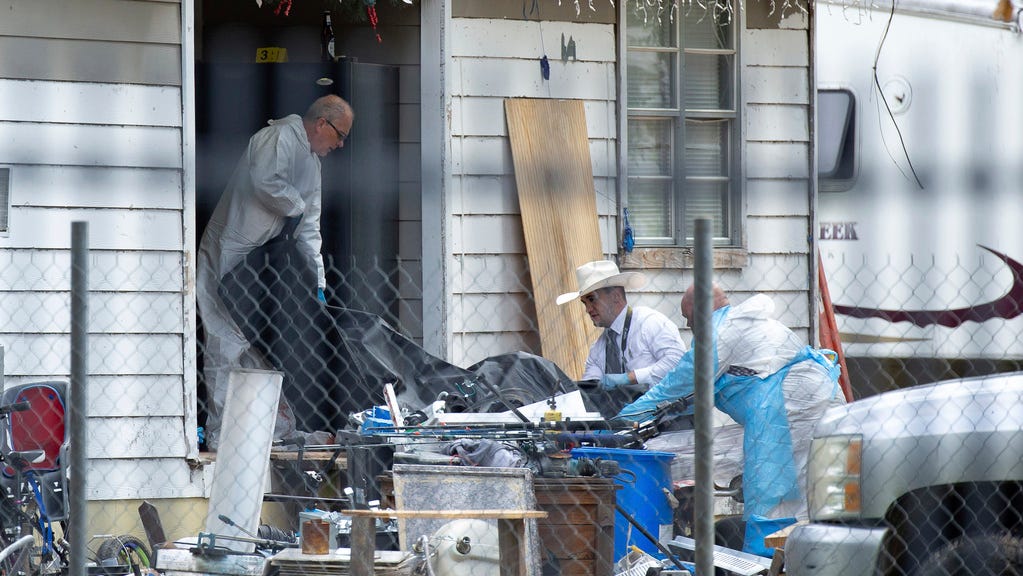 Law enforcement authorities removing bodies from a scene where five people were shot the night before Saturday, April 29, 2023, in Cleveland, TX. Authorities say an 8-year-old child was among five people killed in a shooting at the home in southeast Texas late Friday night.