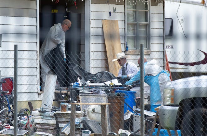 Law enforcement authorities removing bodies from a scene where five people were shot the night before Saturday, April 29, 2023, in Cleveland, TX. Authorities say an 8-year-old child was among five people killed in a shooting at the home in southeast Texas late Friday night.