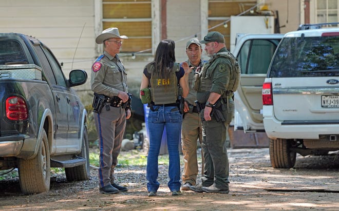 Law enforcement officials are pictured Sunday in the neighborhood where a deadly mass shooting occurred in Cleveland, Texas.