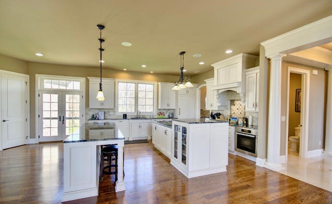 A kitchen with two islands, Sub-Zero and Miele appliances, and lovely hardwood floors.