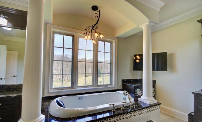 Master bath has a jet Jacuzzi and a great view of the property. Is that a flat screen TV on the wall? Yep.