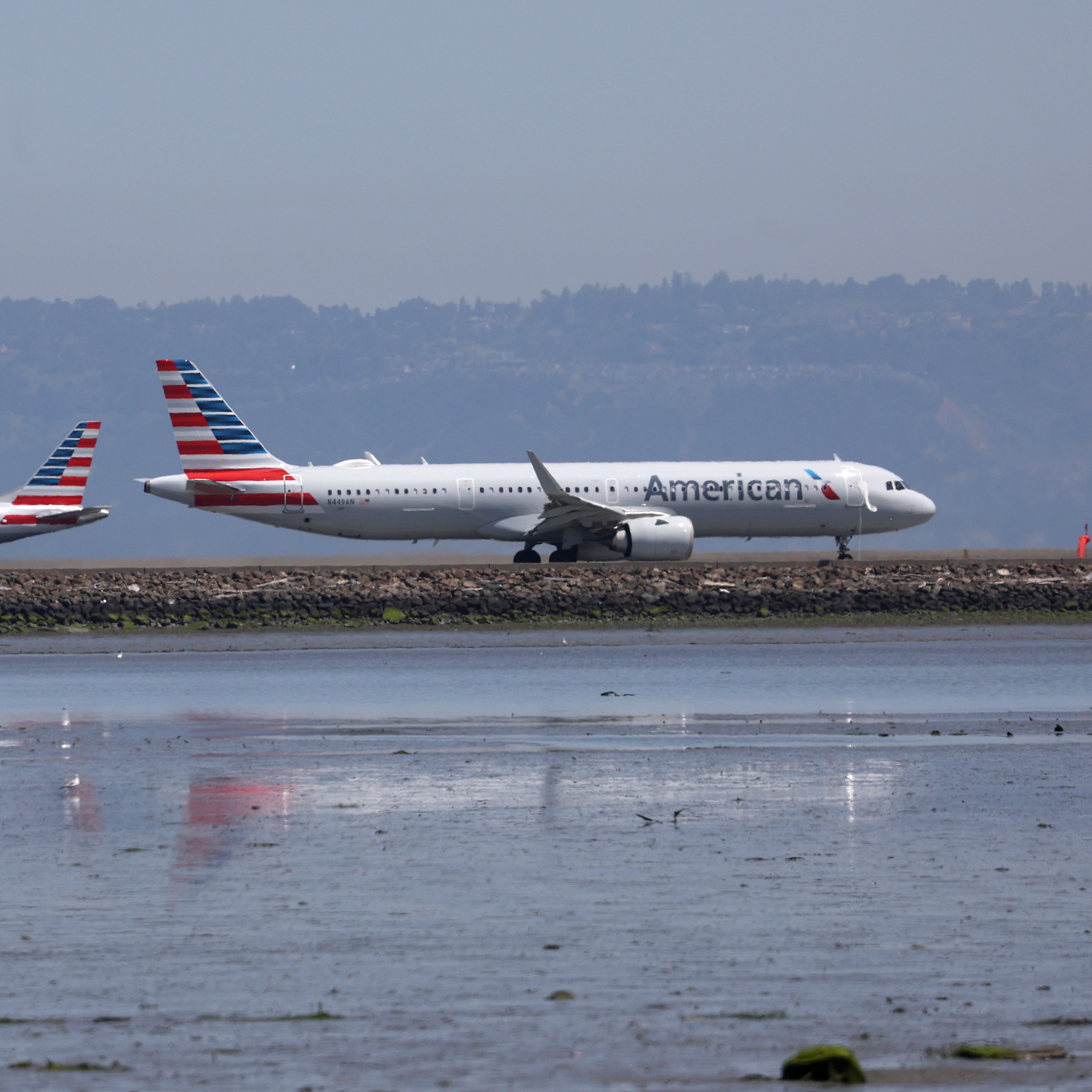 An American Airlines plane prepares to take off past an American Eagle regional jet on the runway at San Francisco International Airport on April 27, 2023. (Photo by Justin Sullivan/Getty Images)