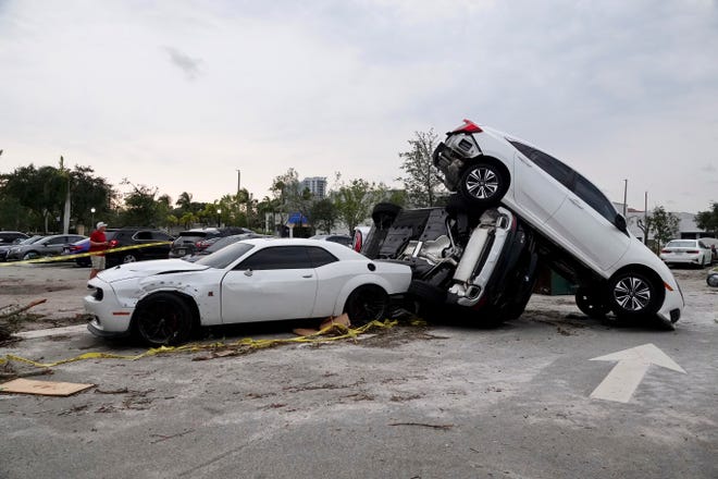 Damaged cars appear in a parking lot after a reported tornado hit the area Sunday in Palm Beach Gardens, Florida.