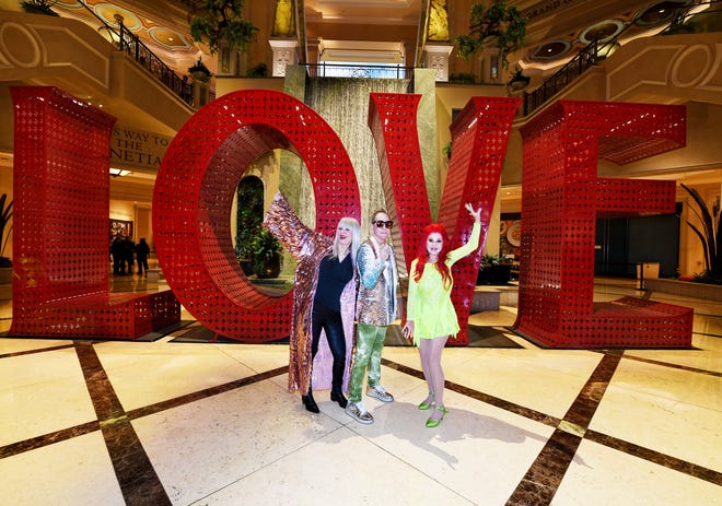 The B-52s - Cindy Wilson, Fred Schneider and Kate Pierson, pose in front of the LOVE sign between the Venetian and Palazzo casino hotels in Las Vegas. Th band will play a 10-show residency at The Venetian starting May 5, 2023.