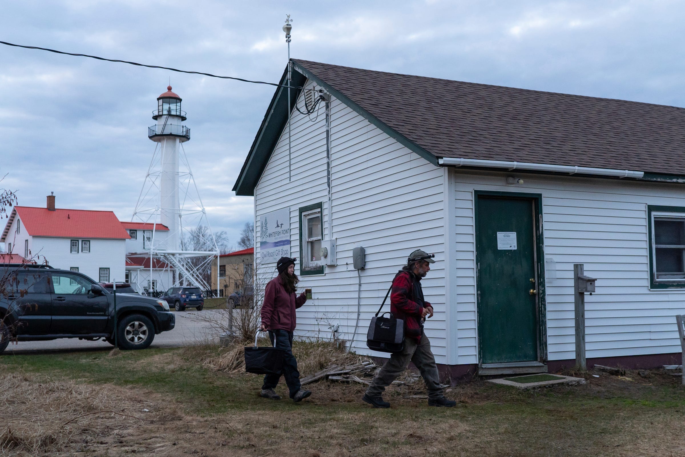 Owl banders Chris Neri, right, and Nova Mackentley arrive at their lab located in the back of a former Owl's Roost gift shop at Whitefish Point Bird Observatory in Paradise on Friday, April 21, 2023, before starting their night banding owls captured along the Lake Superior bay located in Michigan's Upper Peninsula.