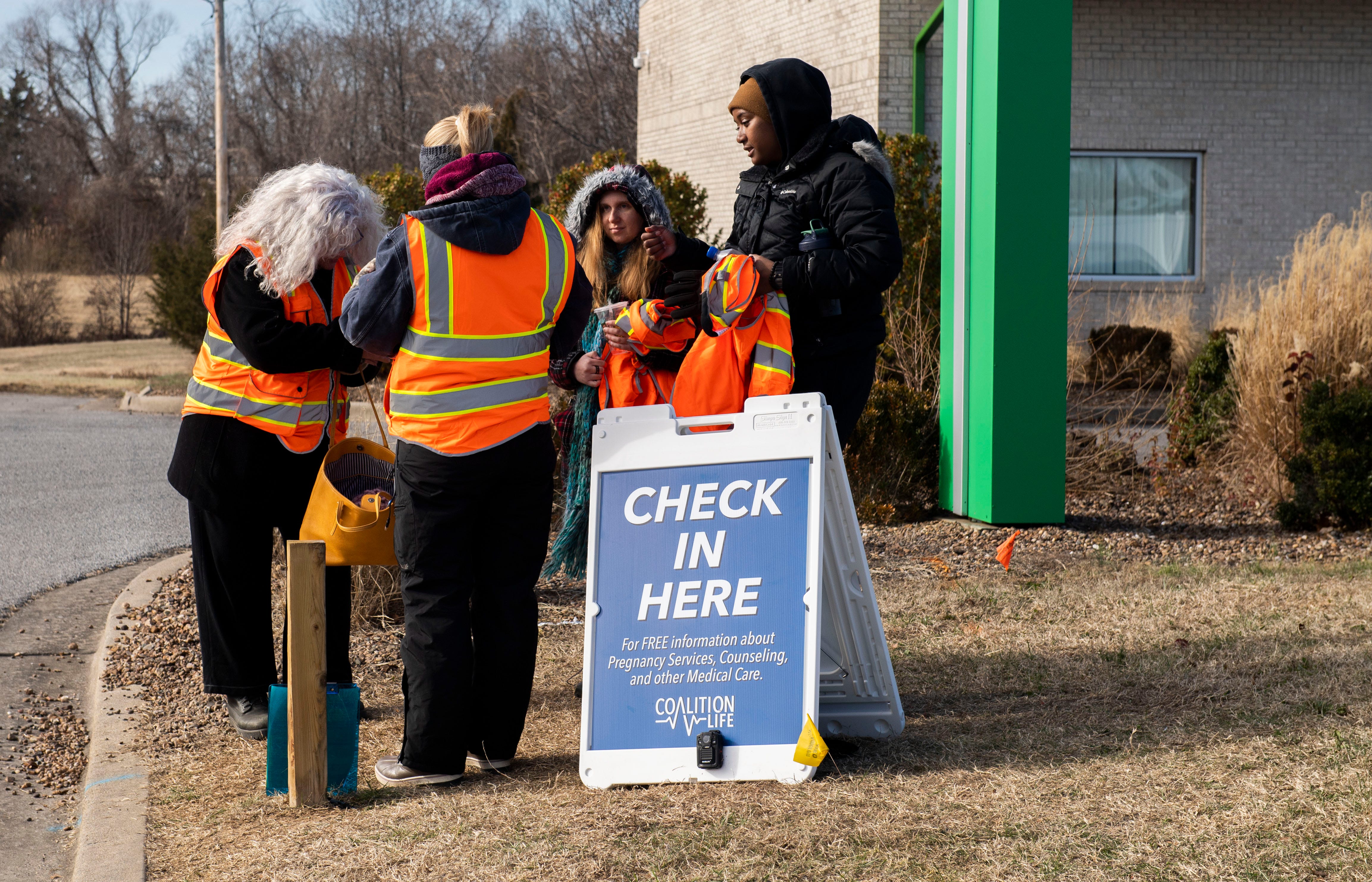 Outside the Choices clinic, people with orange vests and a check-in sign hope to stop arriving women and steer them toward a pregnancy center that encourages alternatives to abortion.