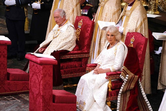 King Charles and Queen Consort seated on the coronation chairs.