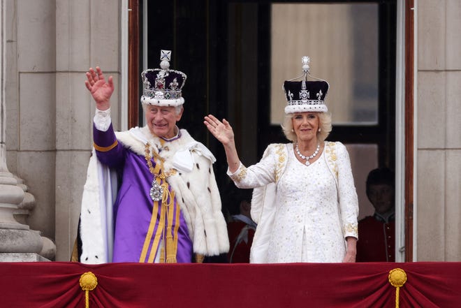 King Charles III and Queen Camilla wave from the Buckingham Palace balcony after the coronation ceremony.