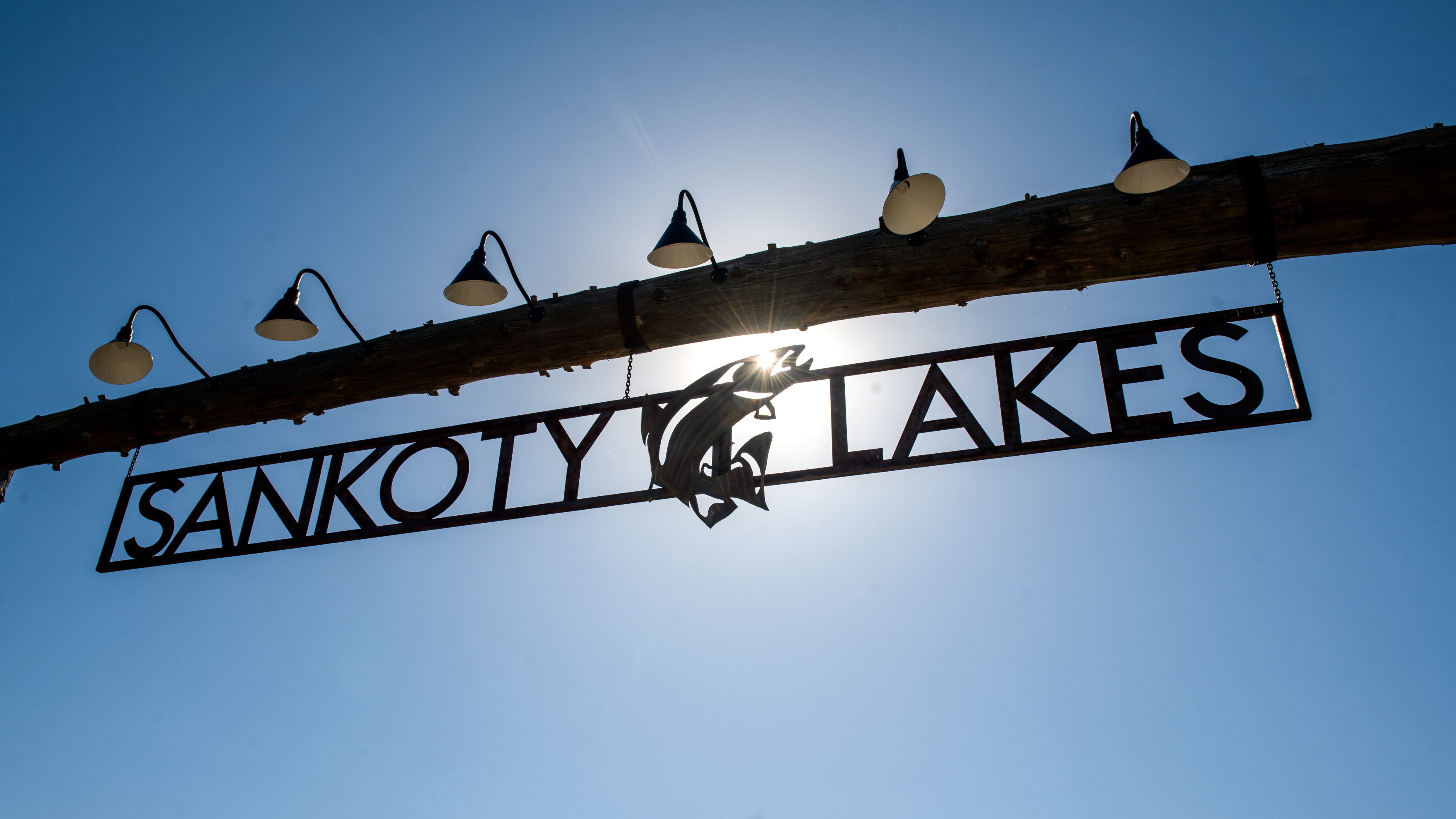 The sun shines through the Sankoty Lakes Resort logo hanging at the entrance to the shuttered property in Spring Bay.