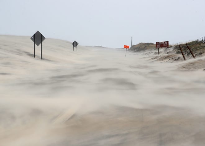 Highway 12 leading onto Hatteras Island is covered with sand after Hurricane Dorian hit the area on September 6, 2019 in Pea Island, North Carolina.