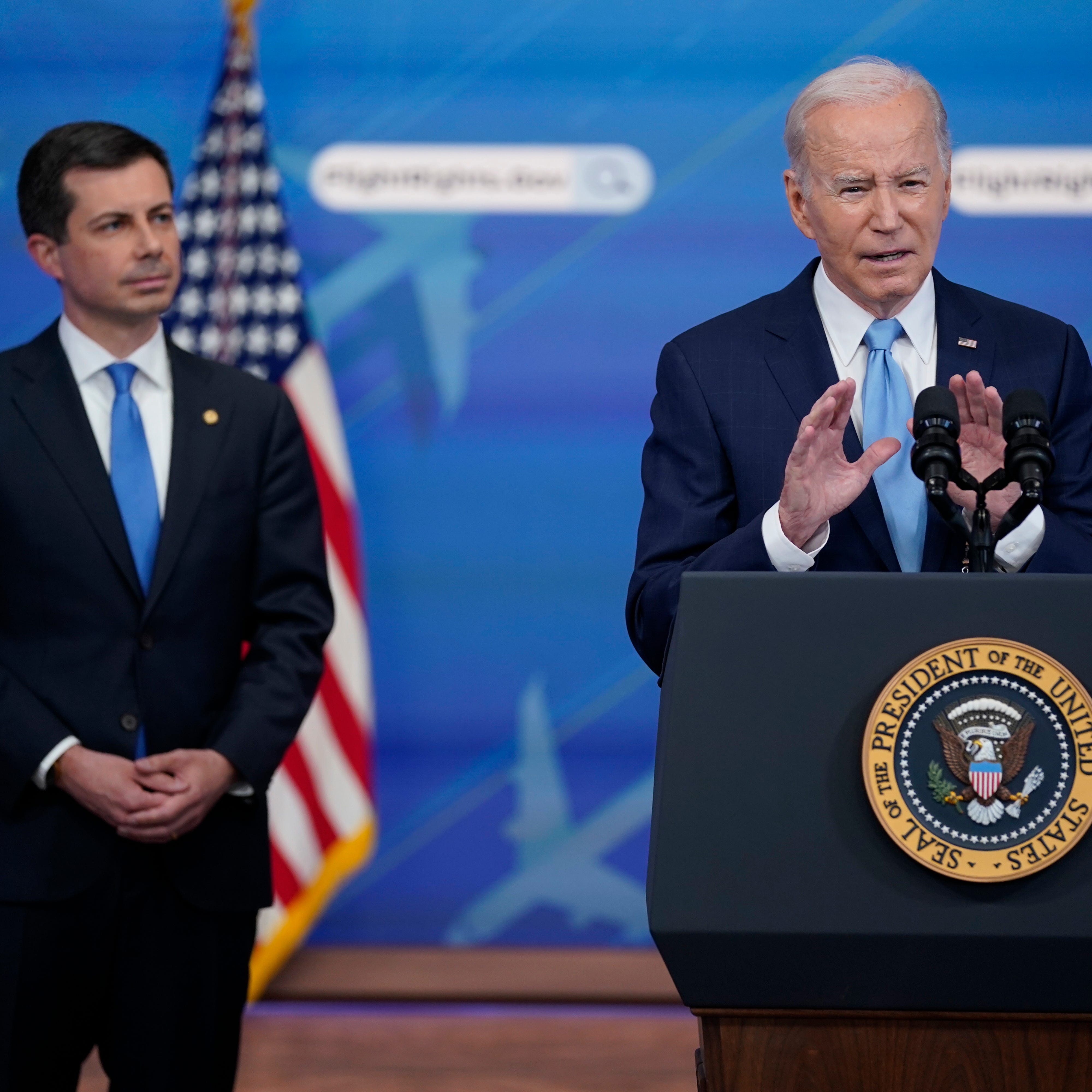 Transportation Secretary Pete Buttigieg listens as President Joe Biden delivers remarks on requiring airlines to compensate passengers for extensive flight delays and cancellations in the South Court Auditorium on the White House complex, Monday, May 8, 2023, in Washington. (AP Photo/Evan Vucci) ORG XMIT: DCEV416
