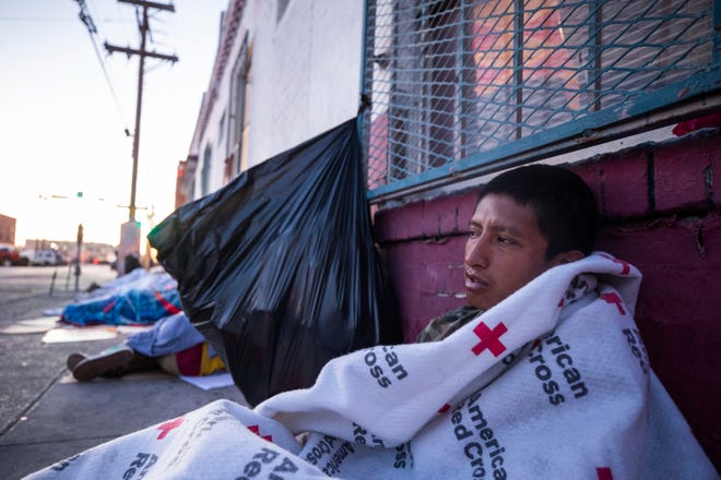 A migrant from Guatemala awakes after sleeping on the street in Downtown El Paso, Texas a block from Sacred Heart Church on Tuesday, May 9, 2023. The church has been a refuge for migrants crossing into the U.S. seeking asylum. 