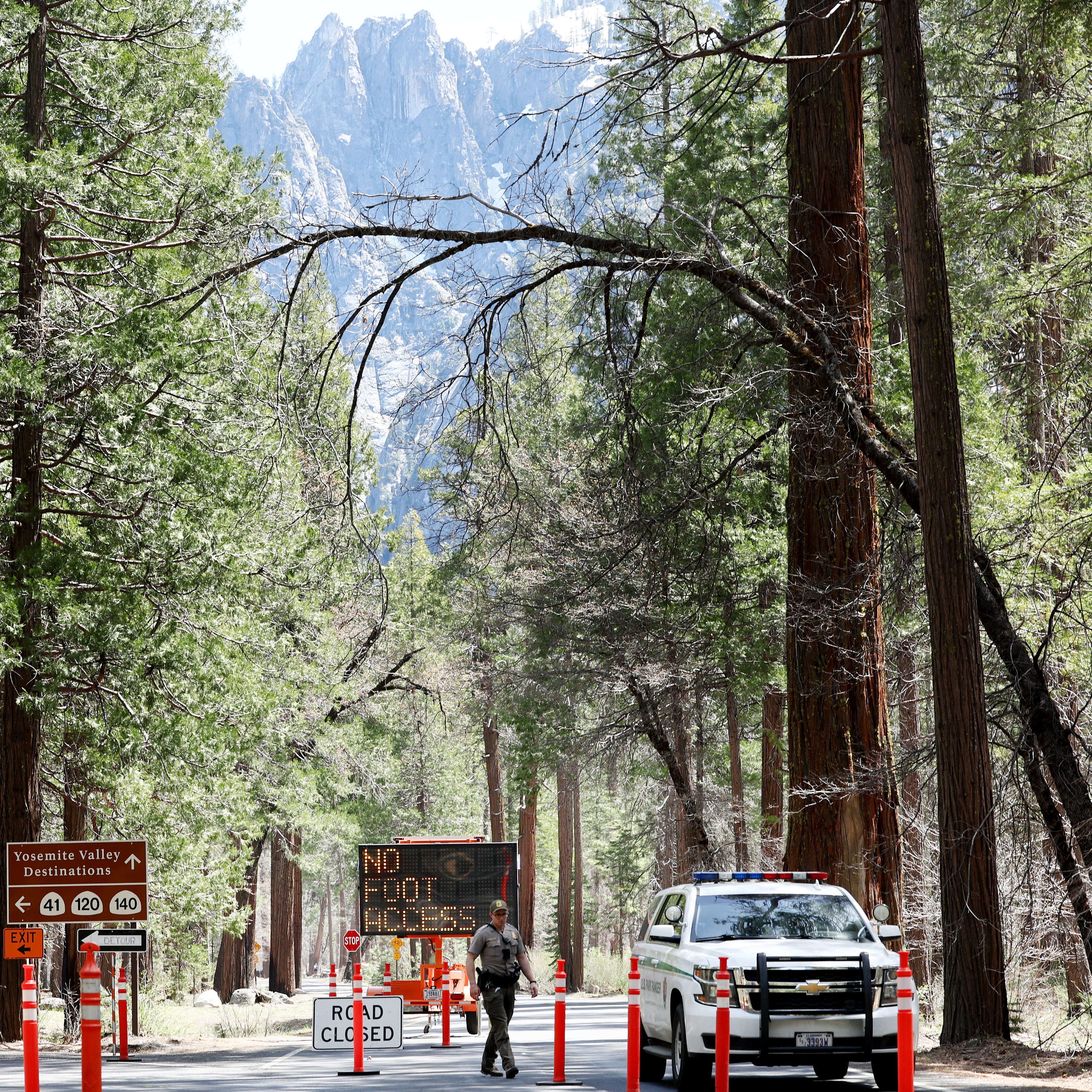 A park ranger keeps watch at a checkpoint for a road closed due to flooding in Yosemite Valley, as warming temperatures have increased snowpack runoff, on April 29, 2023 in Yosemite National Park, California. Most of Yosemite Valley is now closed because of the risk of extensive flooding from the melting snowpack amid a heat wave. As of April 1, snowpack in the Tuolumne River basin of Yosemite National Park was 244% of average amid record snowpack levels for some parts of California after years of drought.
