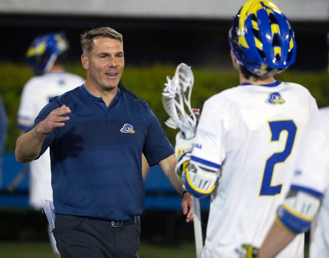 Delaware head coach Ben DeLuca greets Tye Kurtz after the Blue Hens' 25-10 win in the opening round of the NCAA Division I lacrosse championship at Delaware Stadium, Wednesday, May 10, 2023.