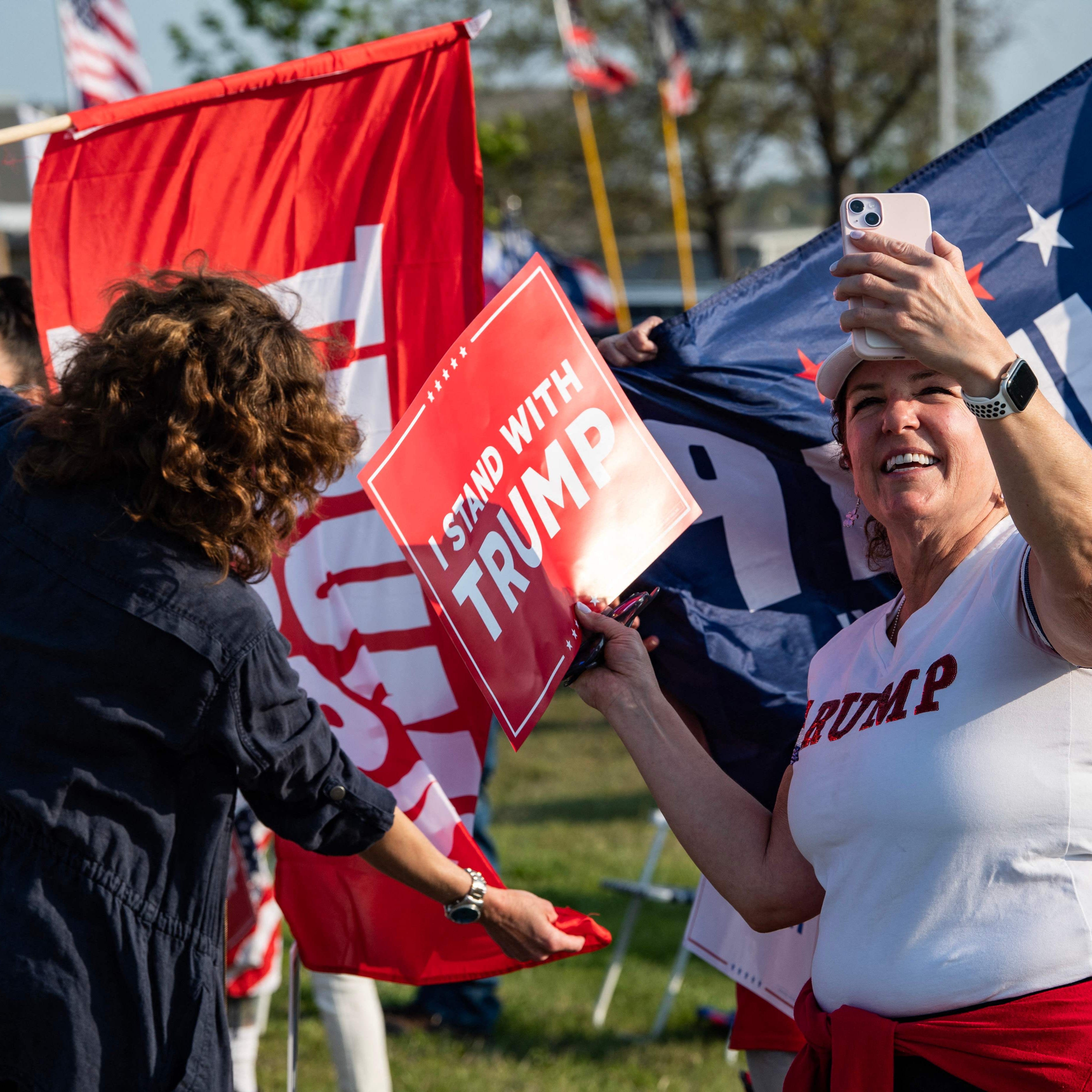 Supporters of former US President and 2024 Presidential hopeful Donald Trump rally to welcome him at Manchester airport in Manchester, New Hampshire, on May 10, 2023 ahead of his CNN town hall meeting.