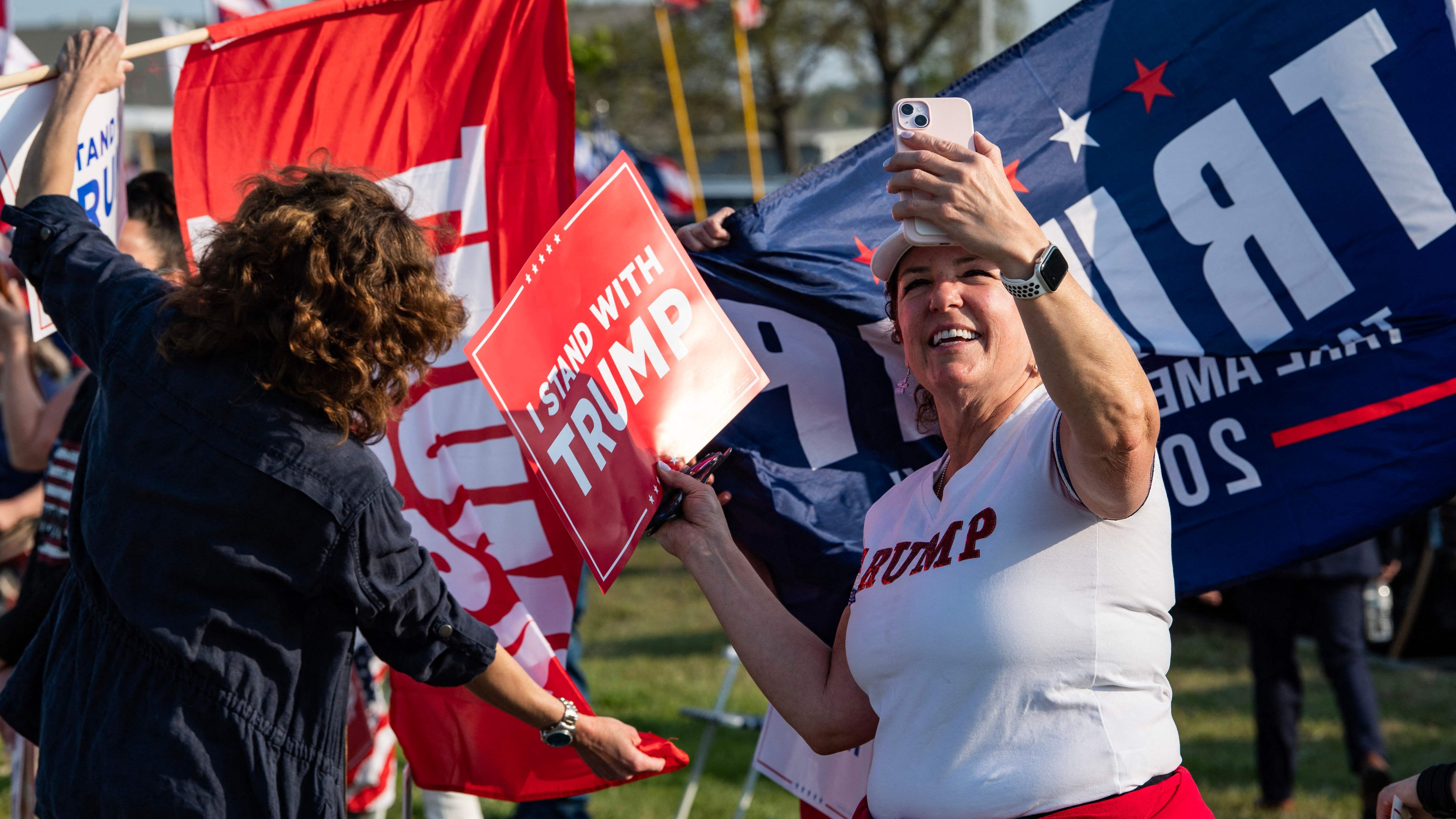 Supporters of former US President and 2024 Presidential hopeful Donald Trump rally to welcome him at Manchester airport in Manchester, New Hampshire, on May 10, 2023 ahead of his CNN town hall meeting.