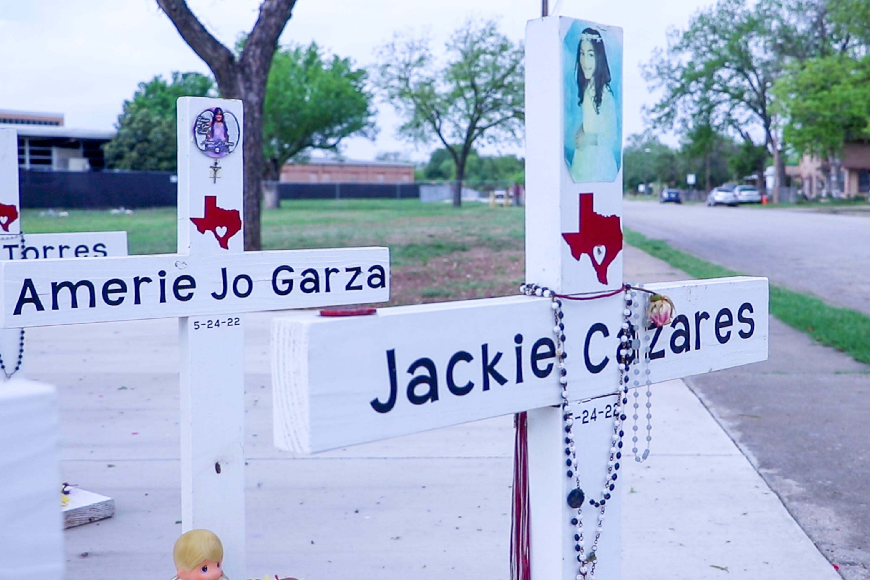 A cross with 9-year-old Jackie Cazares name on it stands amid a memorial in Uvalde to the 19 students and two teachers killed in the mass shooting at Robb Elementary School.