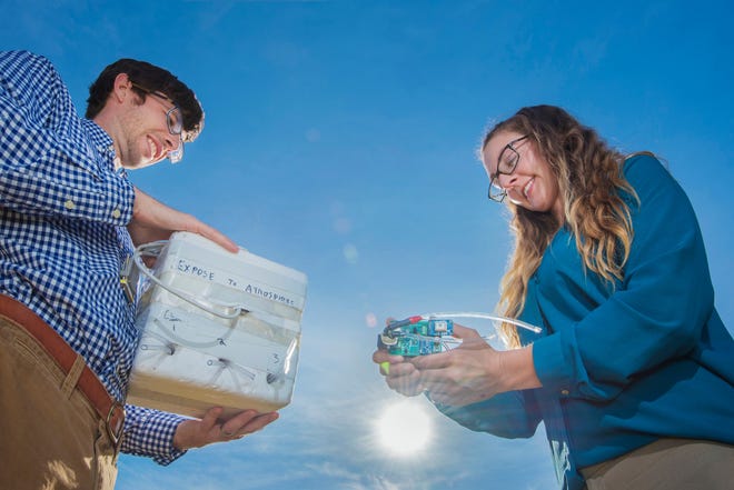Sandia National Laboratories geophysicists Danny Bowman, left, and Sarah Albert display an infrasound sensor and the box used to protect the sensors from the extreme temperatures experienced by balloons that take the sensors twice as high as commercial jets fly.
