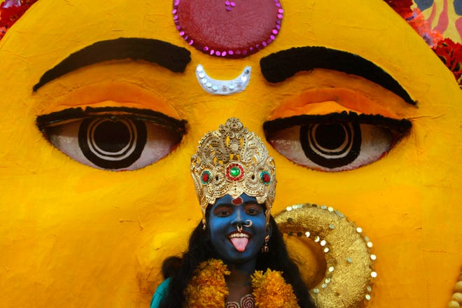 A girl dressed like Kali poses for photographs at a Bonalu festival procession in Hyderabad, India, on Aug. 9, 2010. Bonalu is a month-long festival celebrated in Andhra Pradesh state and is dedicated to Kali, the Hindu goddess of destruction. (AP Photo/Mahesh Kumar A)