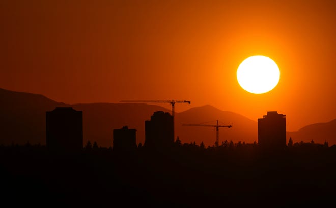 The sun sets over the University District in Seattle on May 13, 2023. Saturday's temperatures reached record-breaking highs for several cities across western Washington.