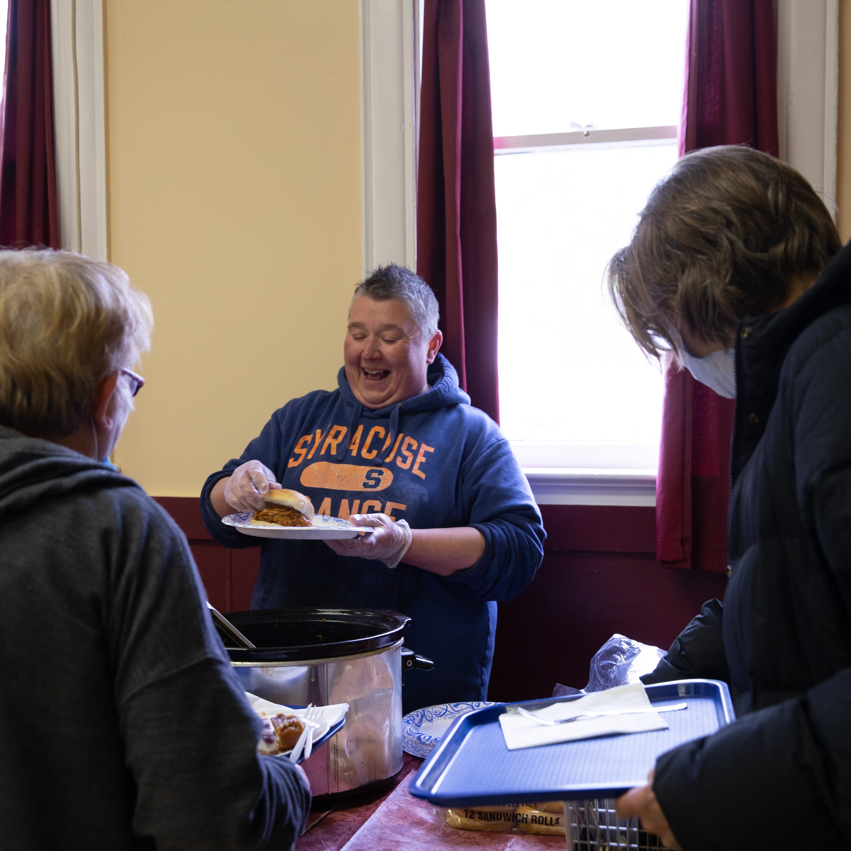 Katie Haney, a member of Rainbow Seniors ROC, prepares and serves meals for the organization’s weekly Tuesday luncheons. The menu on a Tuesday in April consisted of pulled pork sandwiches, pasta salad and a variety of snacks.
