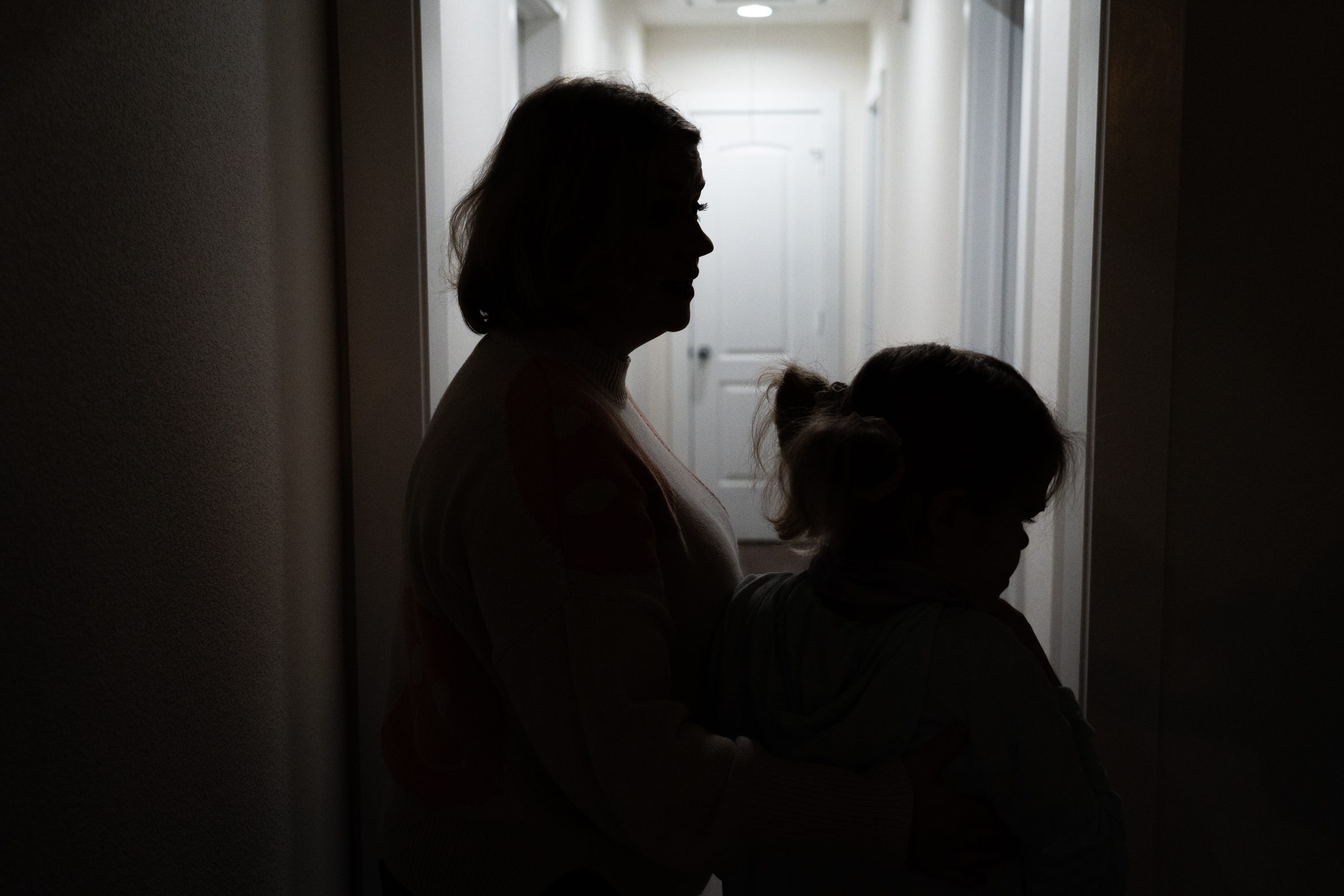 Shiloh Carter helps her daughter, Nola, down the hallway to the bathroom in their home in Friendswood, Texas.