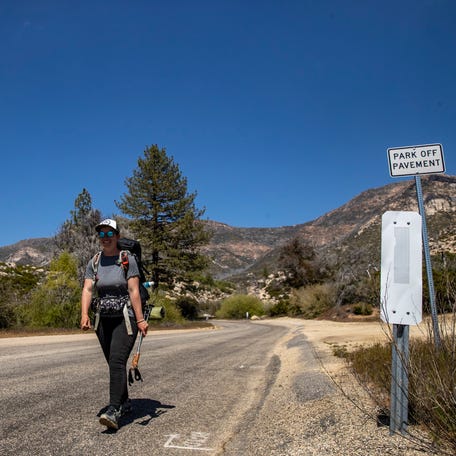 PCT hiker Coline Andre continues down the road on her way to Idyllwild after getting off Spitler Peak Trail in Mountain Center, Calif., Thursday, May 11, 2023. 