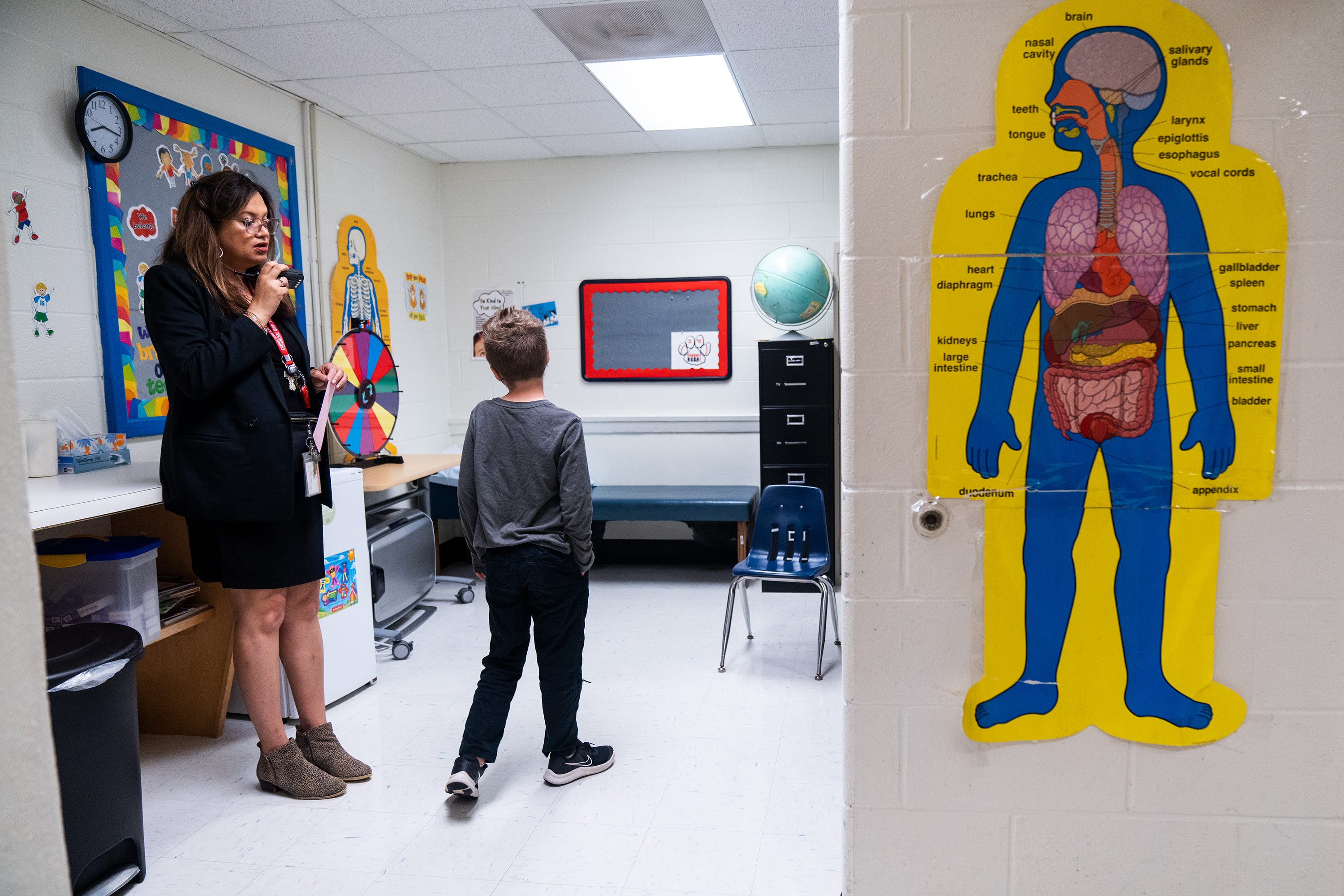 Jasibi Crews, principal of Cora Kelly School, checks on the location of the school nurse after she noticed a student had a poison ivy rash on his face.