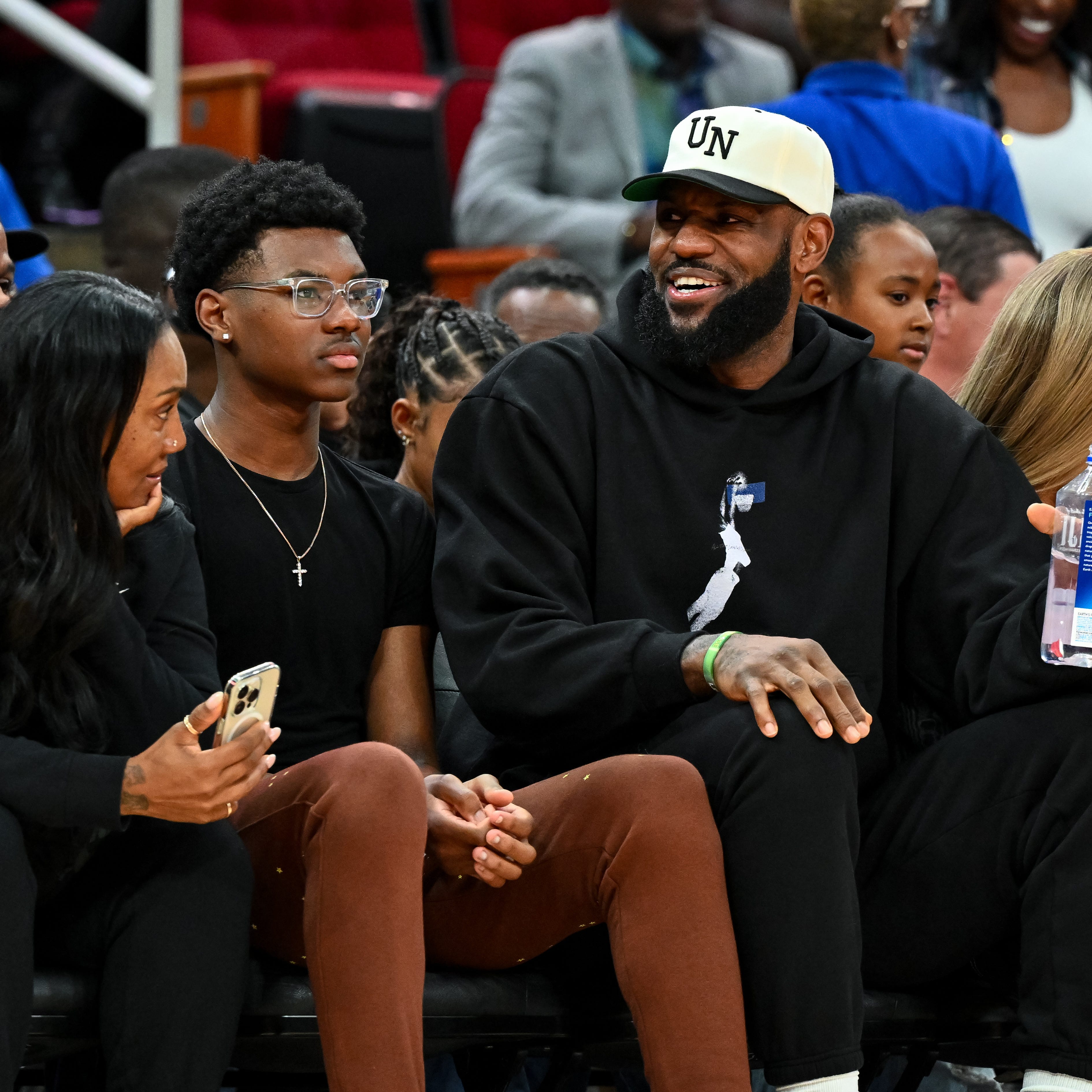 Los Angeles Lakers forward LeBron James sits with his wife Savannah James (right), son Bryce Maximus James (left) and his mother Gloria Marie James (left) court side of the between the McDonald's All American East and the McDonald's All American West at Toyota Center on Mar 28, 2023.