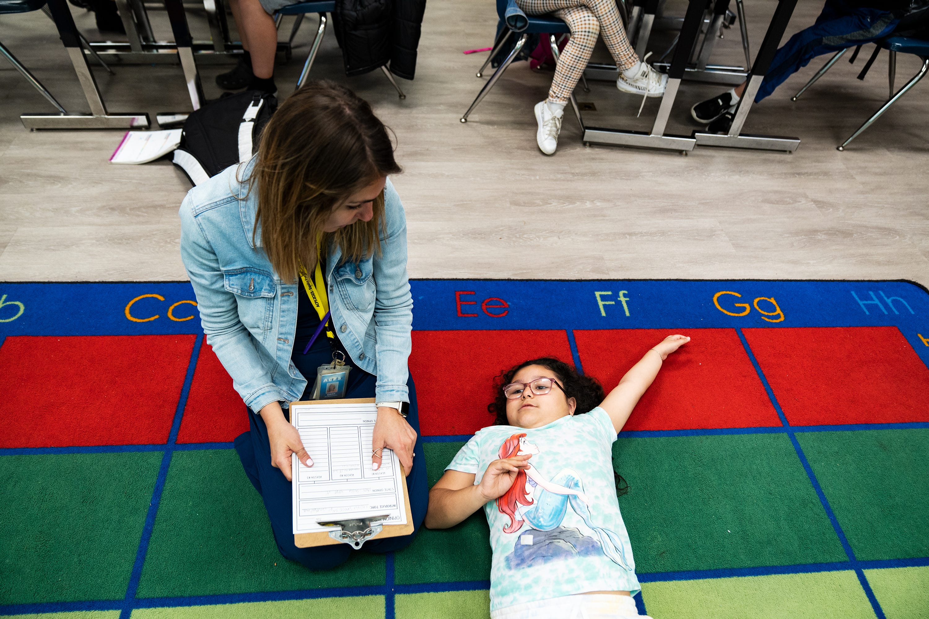 Daisy Andonyadis, a third grade teacher at Cora Kelly School, asks her student, Ashley Soto, to work on her assignment.