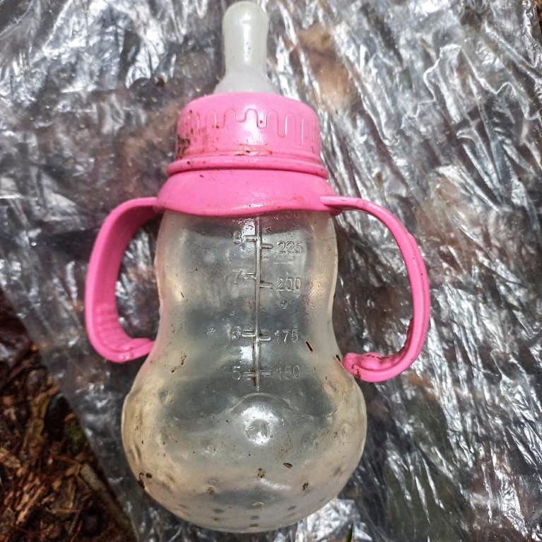 A handout picture released by the Colombian army shows a feeding bottle found in the forest in a rural area of the municipality of Solano, department of Caqueta, Colombia, on May 17, 2023. More than 100 soldiers with sniffer dogs are following the "trail" of four missing children in the Colombian Amazon after a small plane crash that killed three adults, the military said Wednesday.