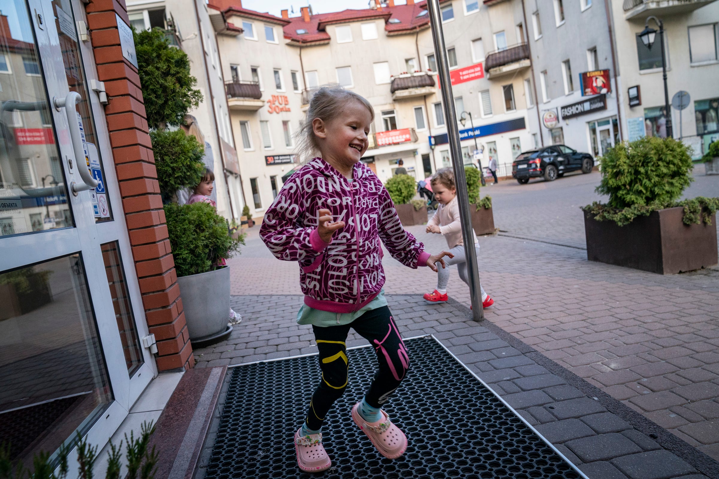 New friends Yelizaveta Nadolniak, 4, of Mykolaiv, Ukraine, left, and Viktoriia Kaleushchenko, 2, of Kharkiv, Ukraine run around their hotel patio in Leczna, Poland on Sunday, May 14, 2023 as the wait for surgeries from Doctors Collaborating to Help Children.