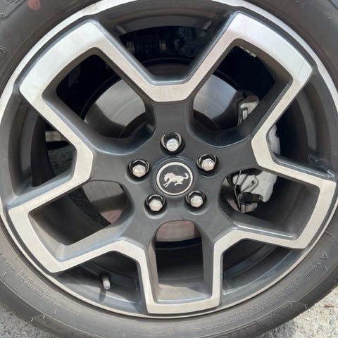 Ford purchases many parts for its Bronco and other vehicles from automotive suppliers. This photo of a Bronco wheel tire shows various components including a unique center cap.