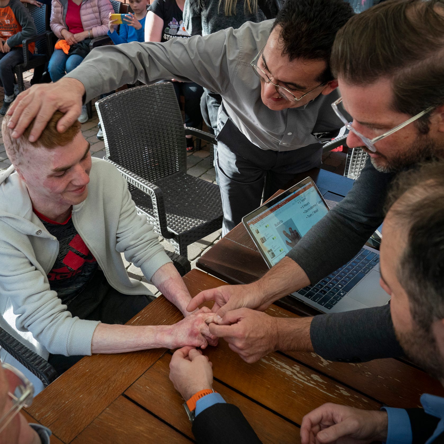 Dr. David Brown, a plastic surgeon from the University of Michigan, left, helps to screen Volodymyr Bubela, 17, of Lviv, Ukraine Sunday, May 14, 2023 on a hotel patio in Leczna, Poland. Brown was joined with Doctors Collaborating to Help Children Founder Dr. Gennadiy Fuzaylov, Dr. Shawn Diamond an Assistant Professor of Plastic Surgery at Texas Tech in El Paso and Dr. Brian Kelley, a plastic surgeon at the University of Texas at Austin Dell Medical School. Bubela was severely burned at the age of 7 in a barn fire and   will have his hands operated on.  