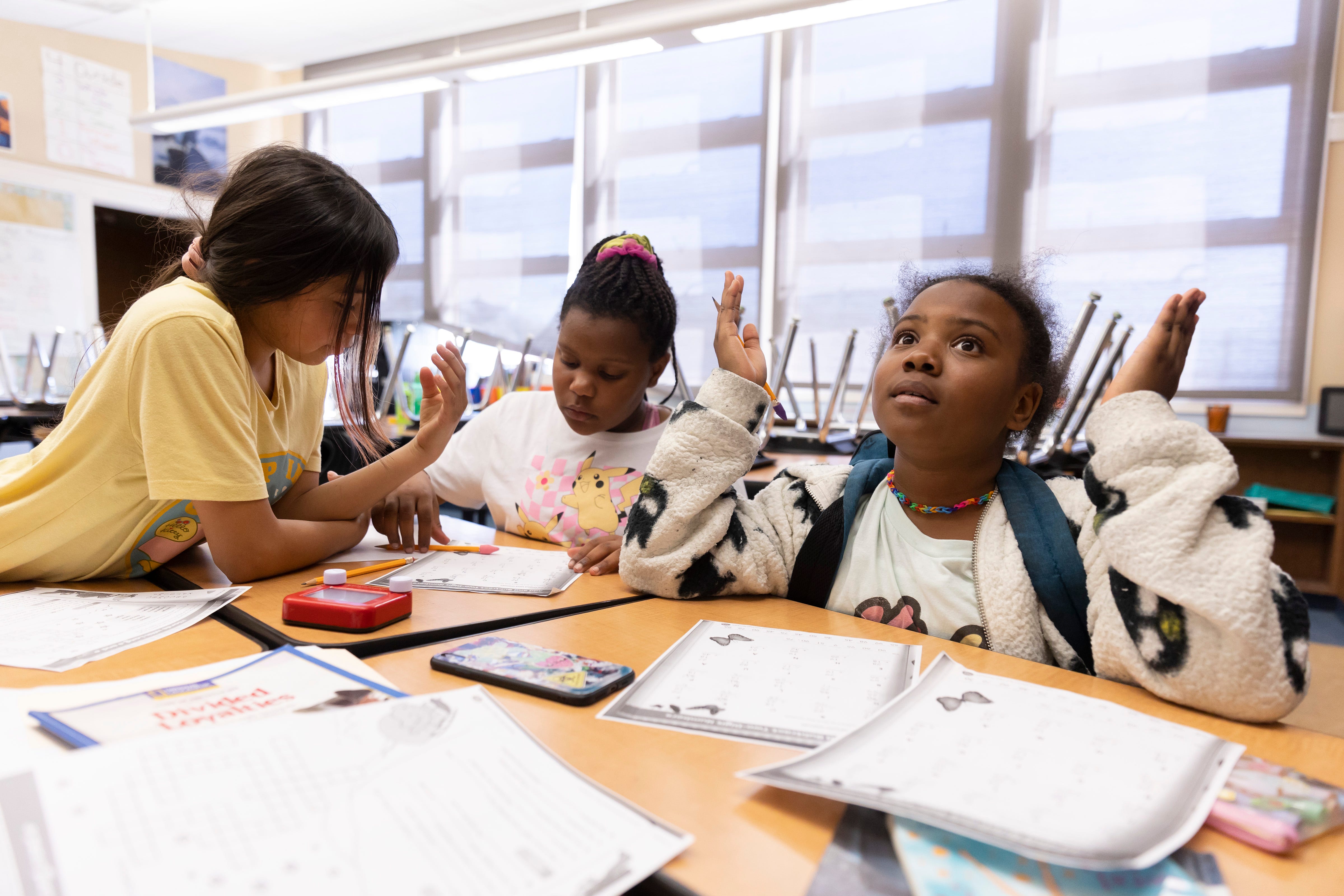 Jada Alexander looks up in frustration while working on math problems with her classmates, Cashmere Barber Jones and Kimberly Aguilar, during their after school program at Nystrom Elementary in  Richmond, Calif.
