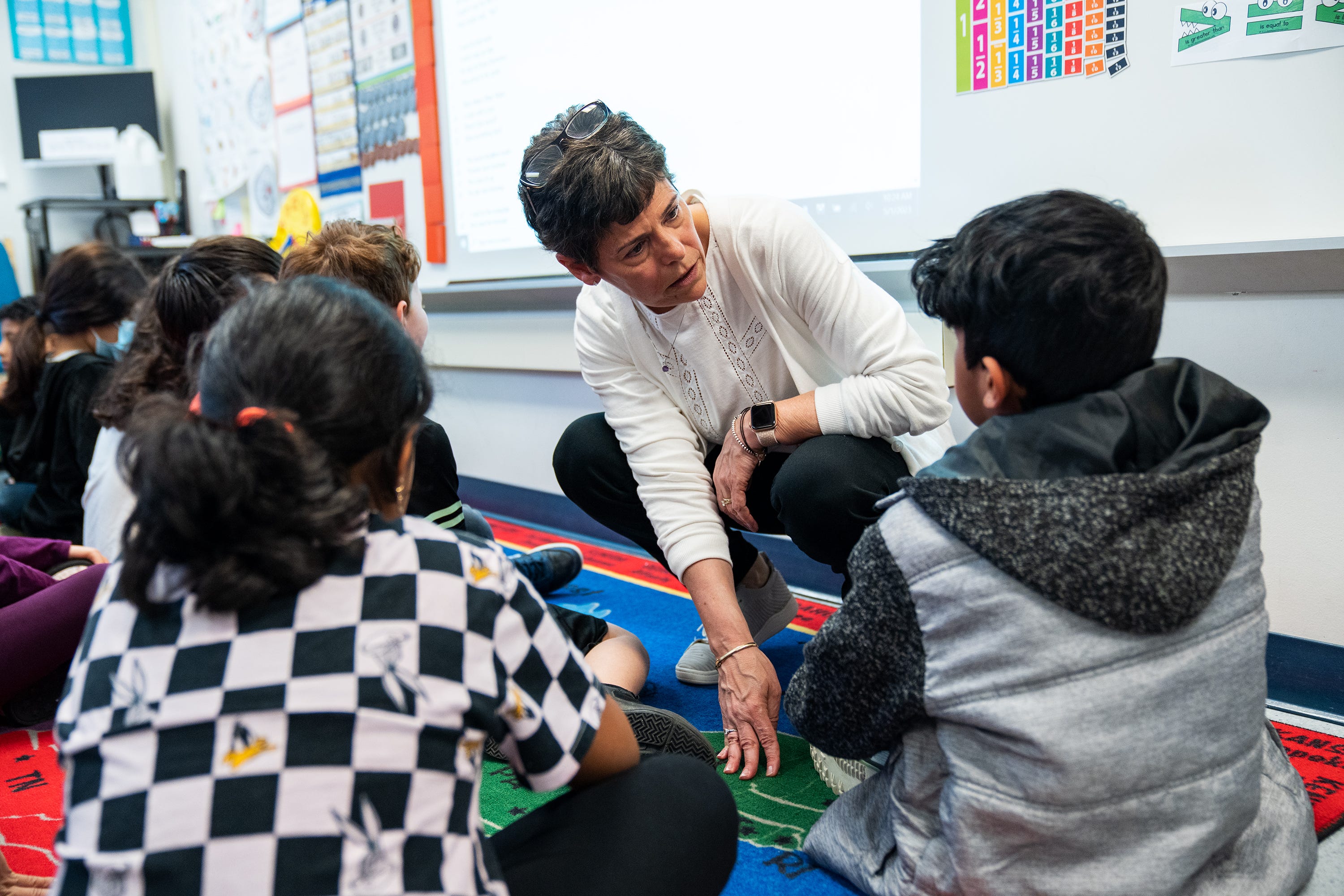 Lisa Cay, third grade teacher at Sleepy Hollow Elementary School in Falls Church, Virginia, checks in on one of her students during class.