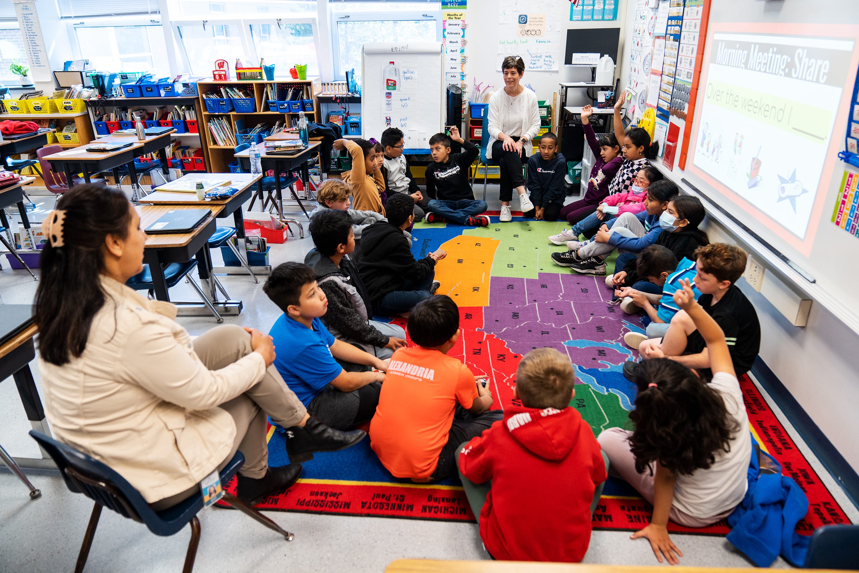 Lisa Cay, (in chair in white) third grade teacher at Sleepy Hollow Elementary School in Falls Church, Va., instructs her students.