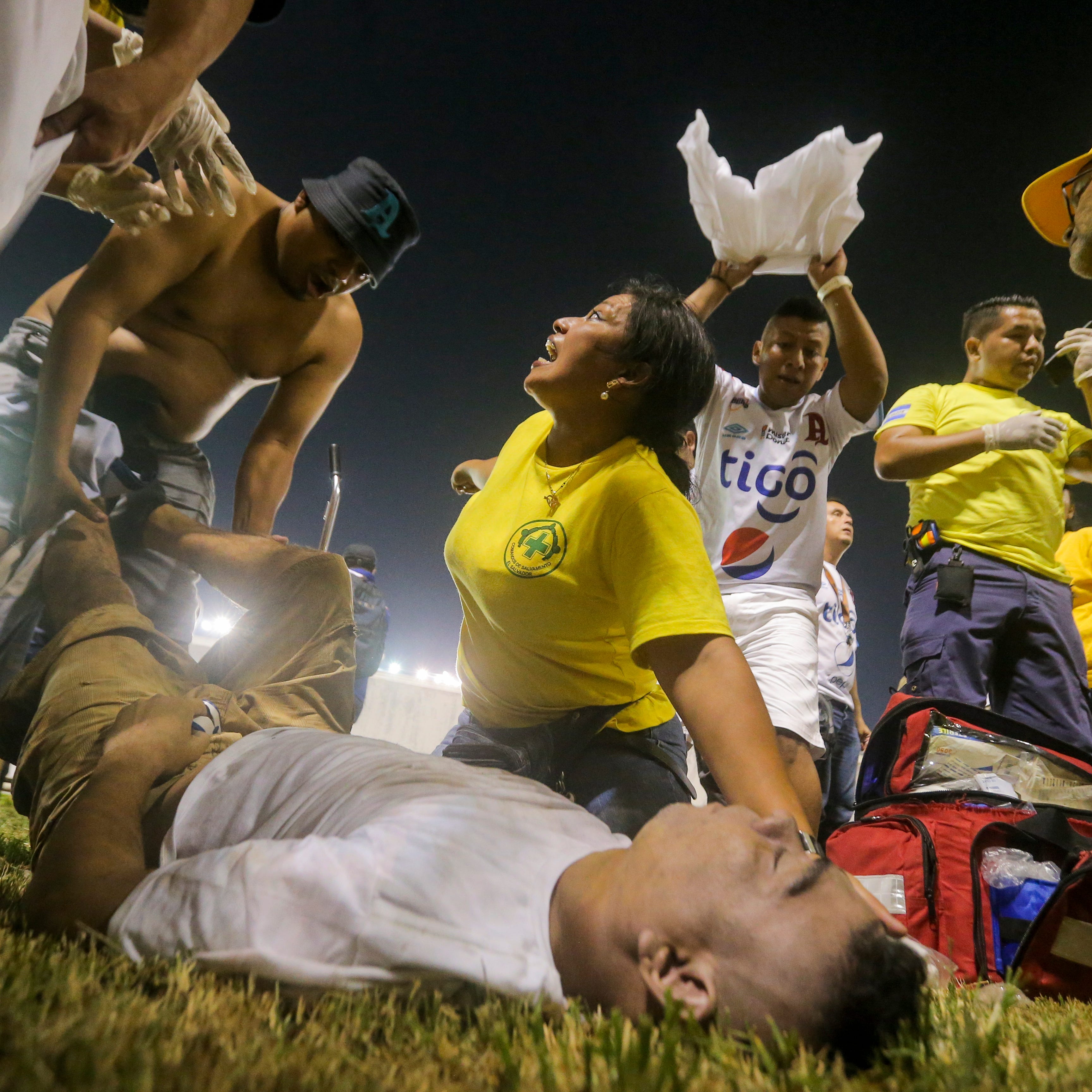 Rescuers attend an injured fan lying on the field of the Cuscatlan stadium in San Salvador, El Salvador.