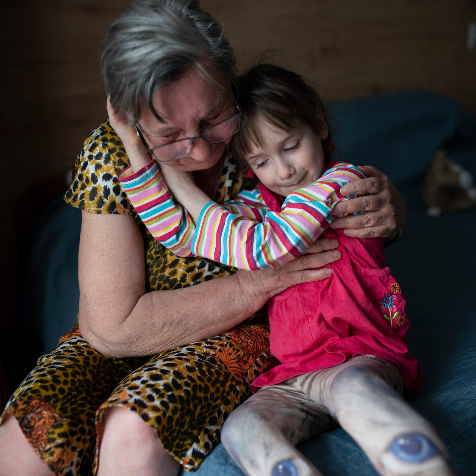 Valentina Ukhvatova, 75, of Dnipro shares a hug with her great granddaughter Evheniia Ukhvatova, 6, of Dnipro, Ukraine, in their hotel room on Wednesday, May 17, 2023 in Leczna, Poland as Evheniia recovers from surgery she had the twos days before. Evheniia Ukhvatova had surgery on burn scars that cover the backs of her legs and feet due to the contractures of old scar tissue.