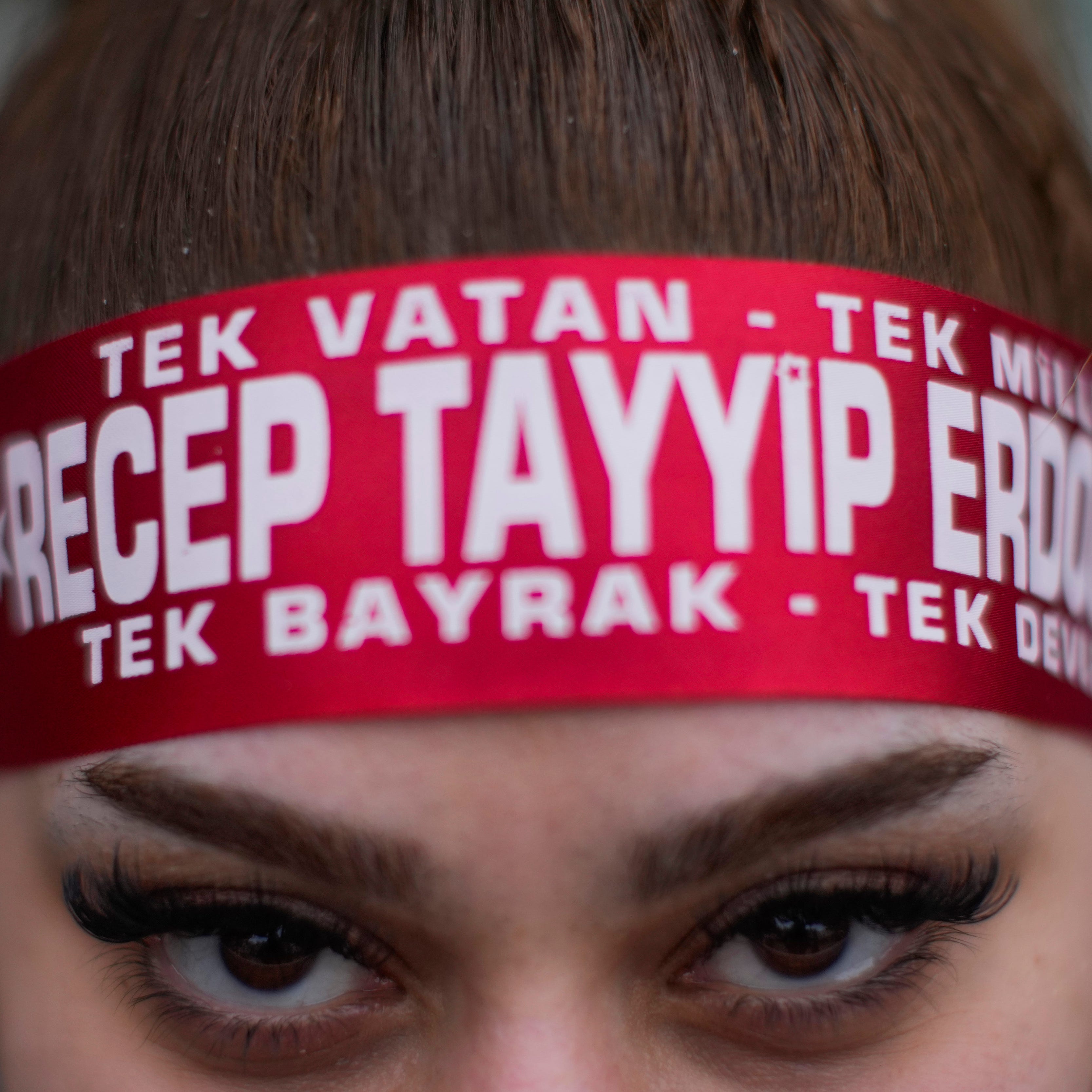 A supporter of President Recep Tayyip Erdogan stands outside the headquarters of his AK Party in Istanbul, on May 14, 2023.