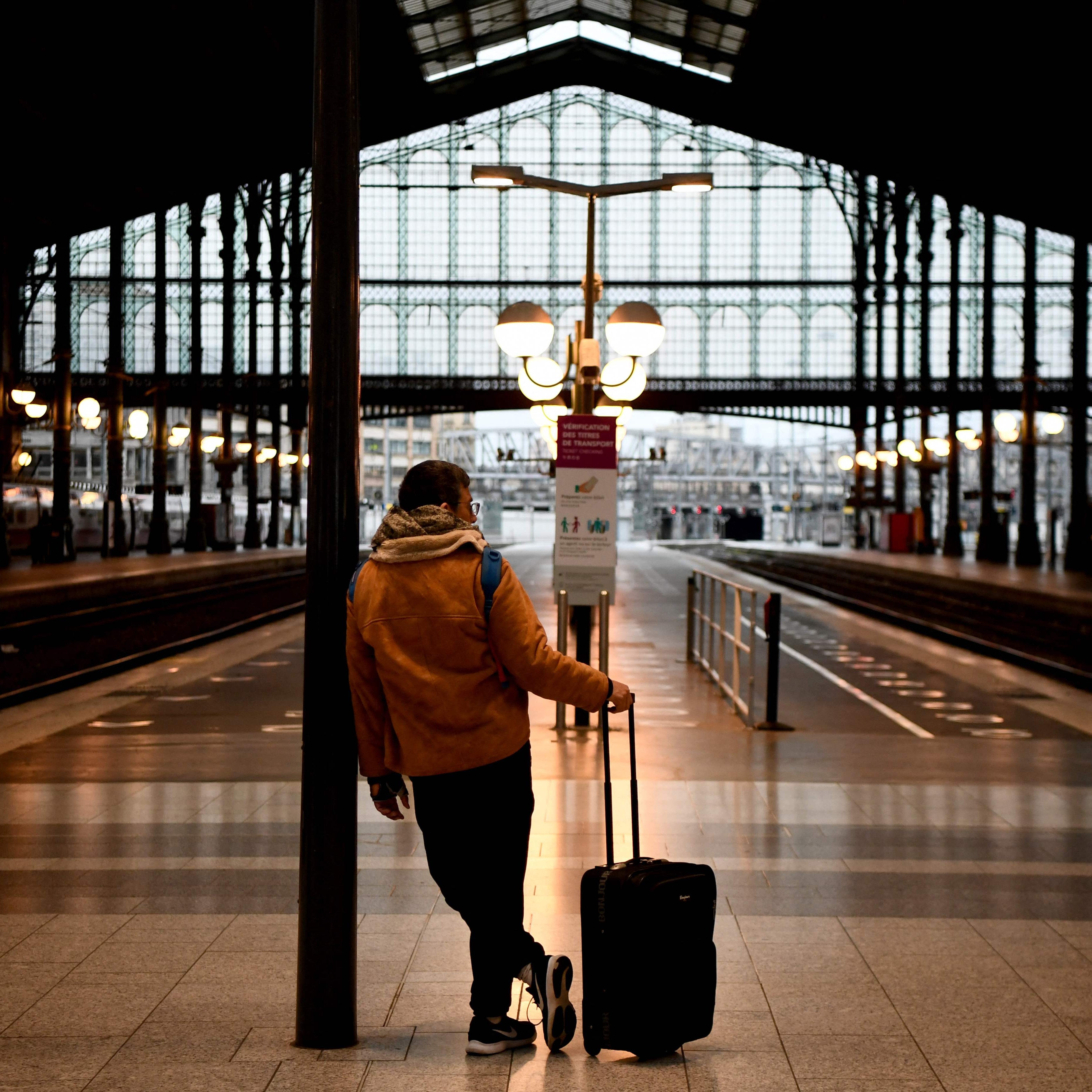TOPSHOT - A traveller waits in front of platforms at Gare du Nord train station in Paris on a new day of nationwide strikes and protests against the government's pension reform plan on March 23, 2023. - France braced for more transport woes and a new day of nationwide protests on March 23, 2023 after a defiant President Emmanuel Macron pledged to implement a contentious pensions overhaul by year-end. (Photo by Christophe ARCHAMBAULT / AFP) (Photo by CHRISTOPHE ARCHAMBAULT/AFP via Getty Images) ORIG FILE ID:   AFP_33BV7VM.jpg