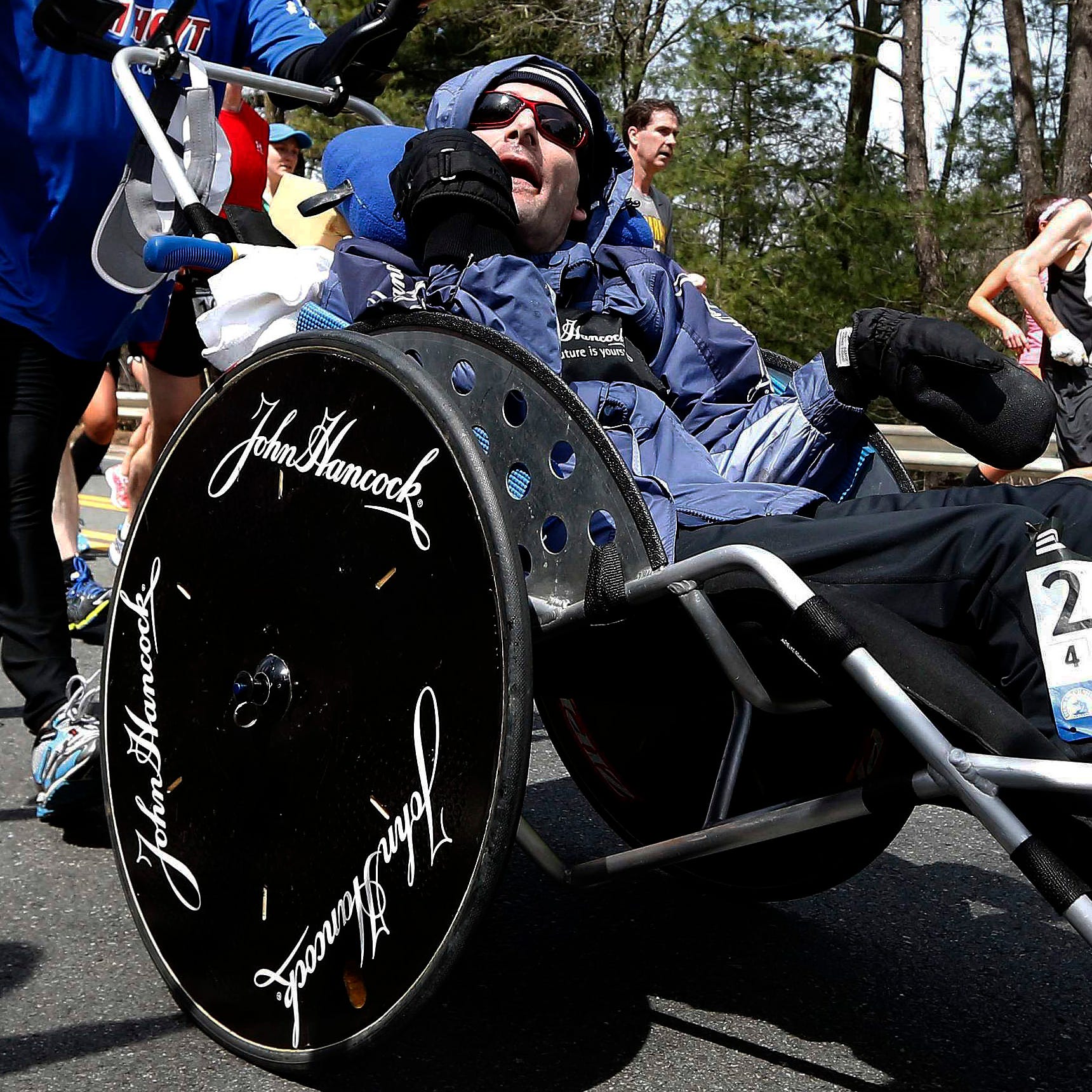 Rick Hoyt, center, is pushed by his father Dick at the 2013 Boston Marathon. The Hoyt became a fixture at the Boston Marathon and other races for decades.