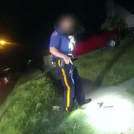 A Mantua police officer examines the scene of the fatal police shooting of Charles Sharp III in September 2021.
