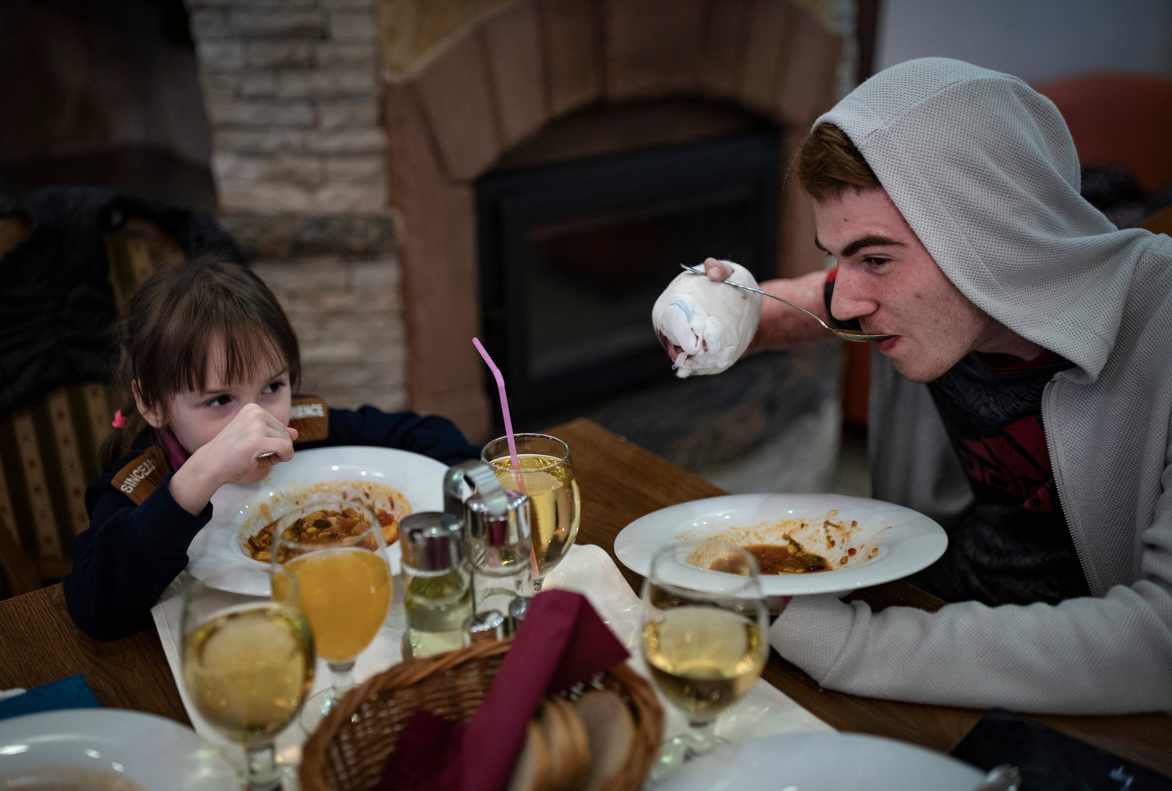 Evheniia Ukhvatova, 6 ans, de Dnipro, en Ukraine, est assise avec son nouvel ami Volodymyr Bubela, 17 ans, alors qu'ils mangent de la soupe dans le restaurant de leur hôtel le mercredi 17 mai 2023 à Leczna, en Pologne.  Tous deux ont été opérés la veille pour leurs cicatrices de brûlures.