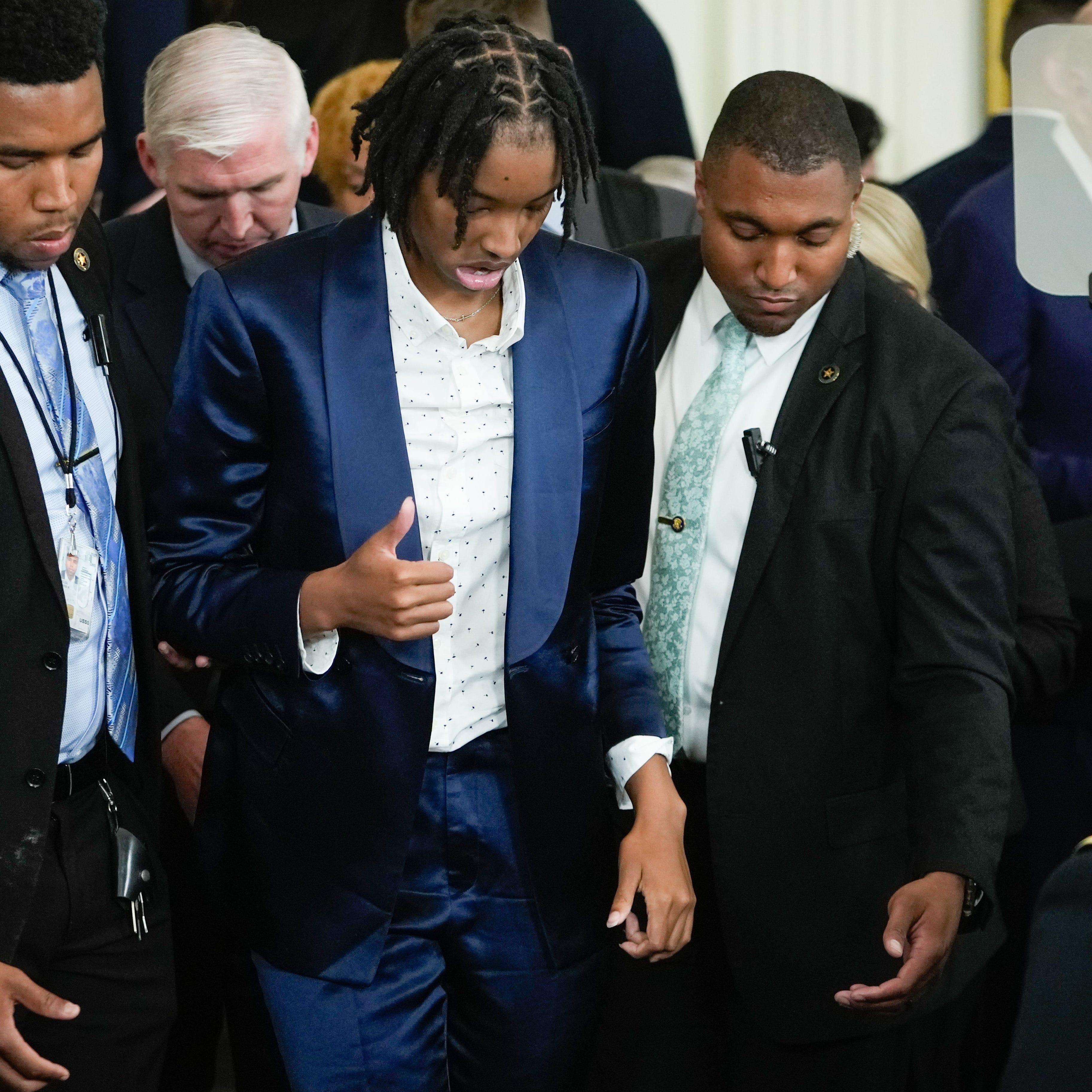 LSU women's basketball player Sa'Myah Smith, center, stands up after passing out during a White House ceremony honoring the team's national championship with President Joe Biden and first lady Jill Biden.