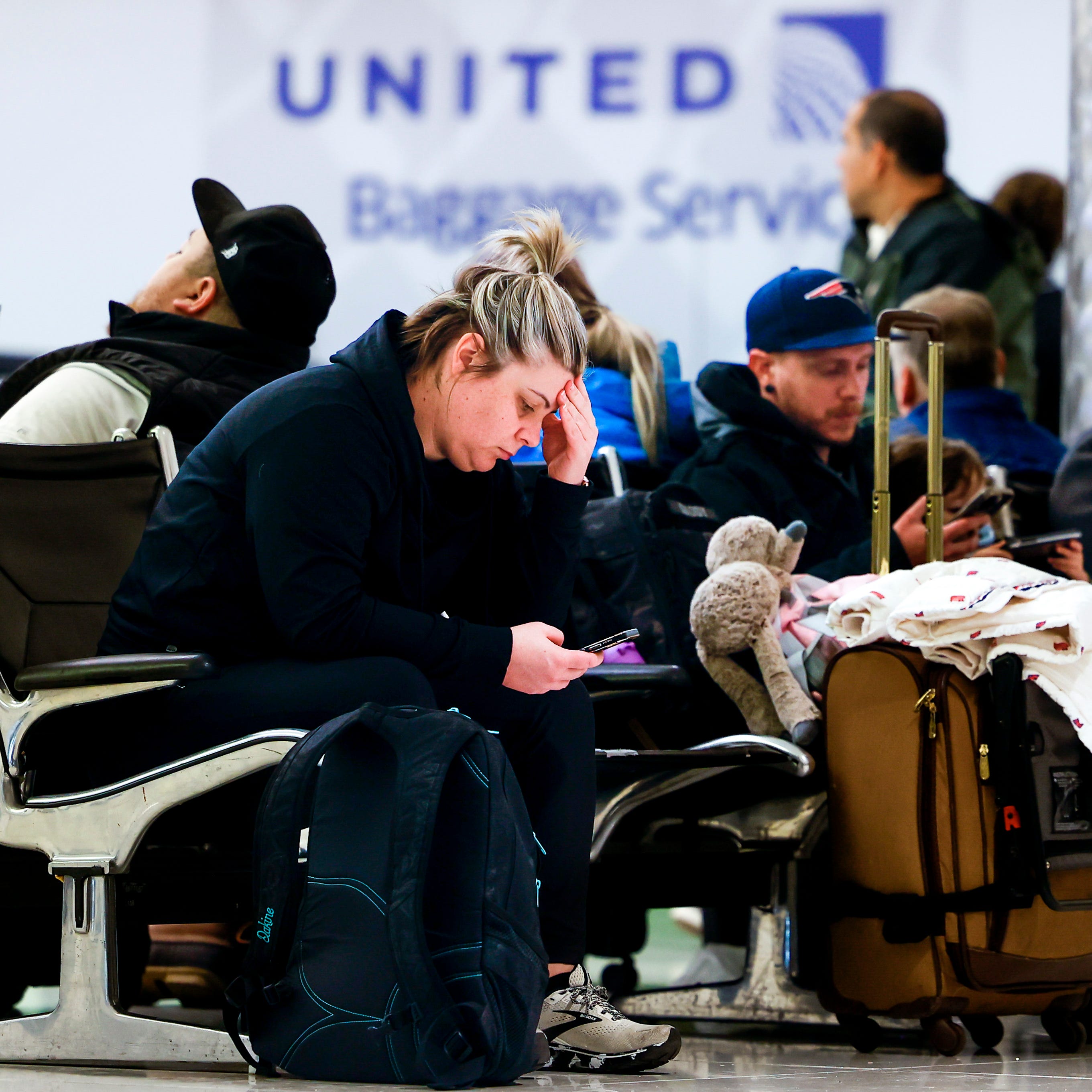 Mairi Risner sits at Denver International Airport after her flight was canceled due to a winter storm on February 22, 2023.
