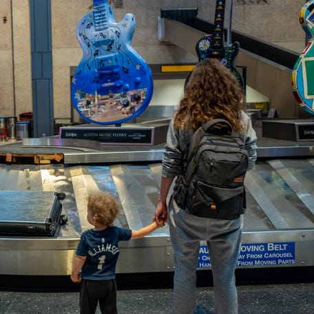 A family waits for their luggage at the Austin-Bergstrom International Airport on May 26, 2023, in Austin, Texas. Millions of Americans are expected to travel this Memorial Day Weekend as gas has become a dollar cheaper than last year.