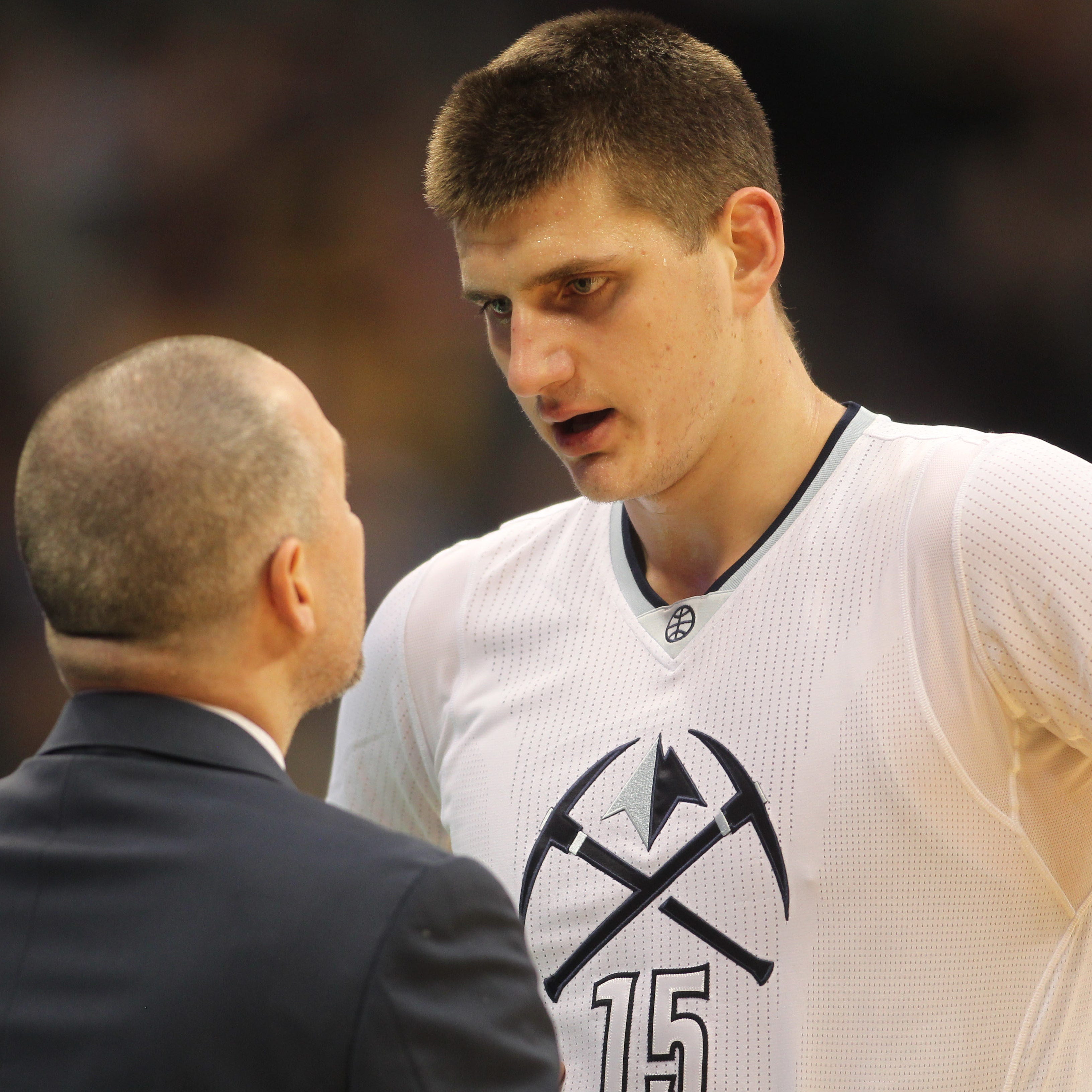 This file photo from Dec. 15, 2016 shows Nuggets coach Michael Malone, left, talking with Nikola Jokic during the first half of a regular-season game at Pepsi Center in Denver.